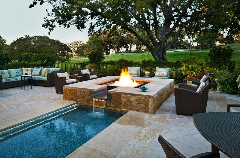 A cool water feature and fireplace that complements a larger pool perfectly