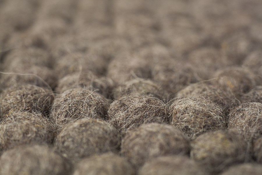 Closer look at the raw earth felt ball rug