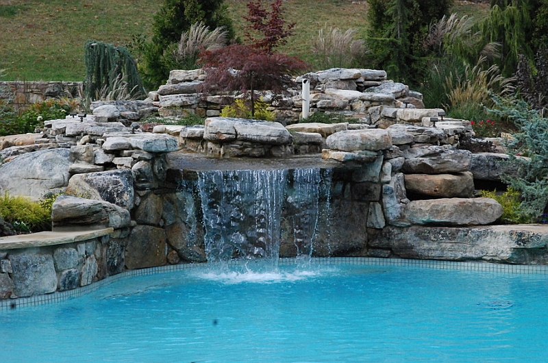 Custom large scale swimming pool with a natural waterfall feature