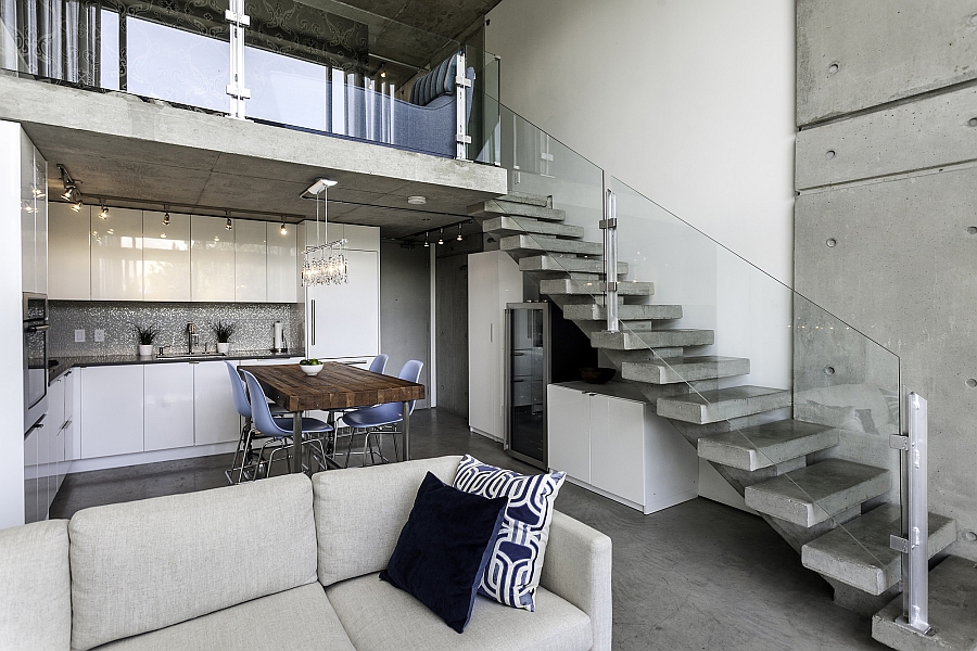 Glass railing for the concrete staircase brings a sense of visual airiness