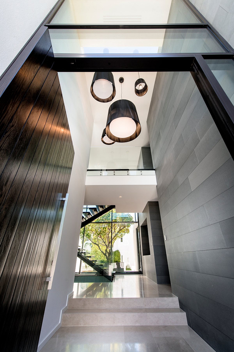 Large pendants hold their own in the hallway with high ceiling