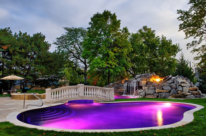 Lighting waterfalls and fireplace shape the stunning poolside landscape