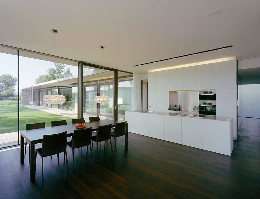 Minimalist kitchen along with sparkling caboche chandeliers above the dining table