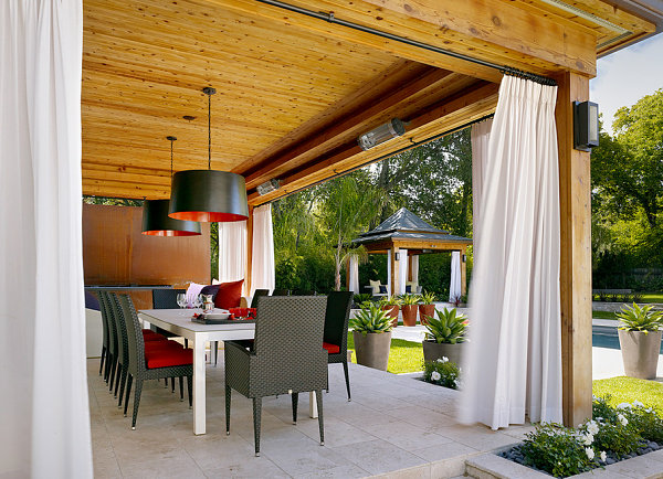 An outdoor lounge with white curtains