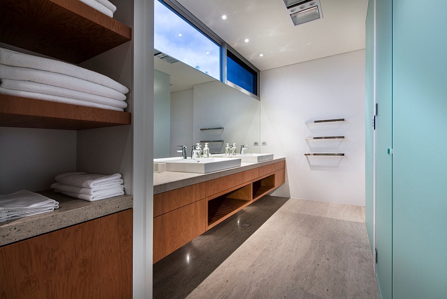 Sleek contemporary bath in white with floating wooden vanity