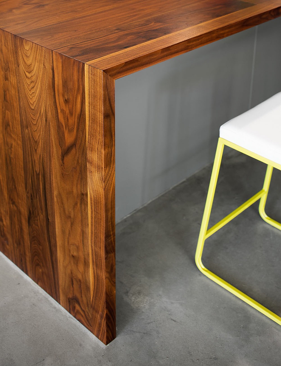 Sleek kitchen bar stools in yellow coupled with more rustic wooden elements