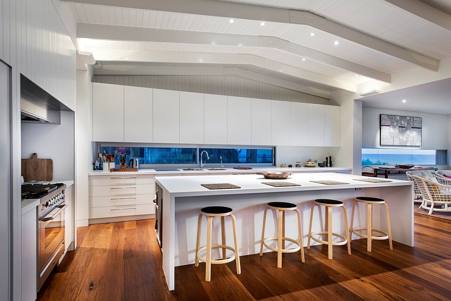 Smart bar stools add visual contrast to the all-white kitchen