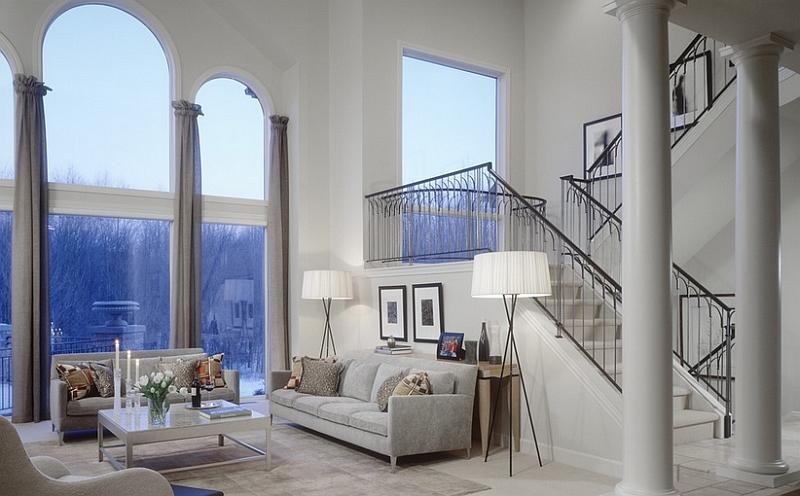 Tripod lamps in the family room with a high ceiling bring visual balance and proportion