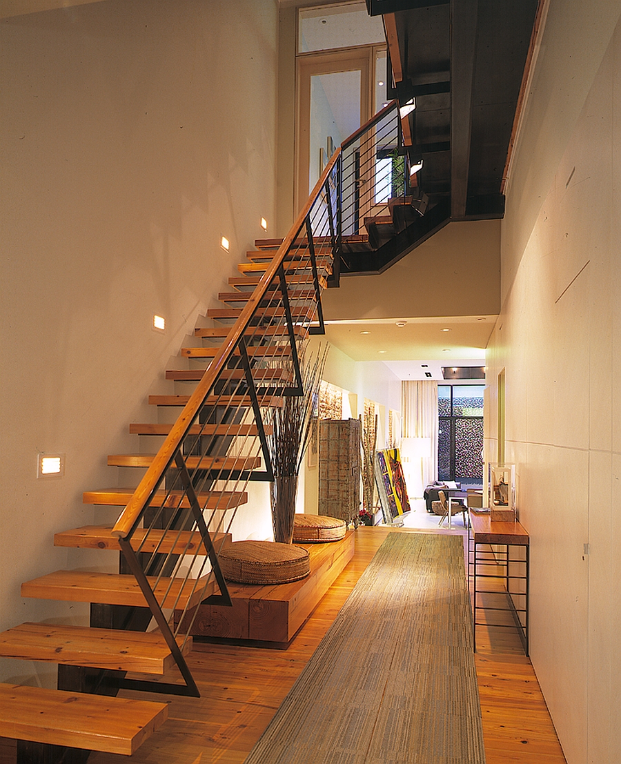 Addition of wooden staircase brings visual warmth to the house