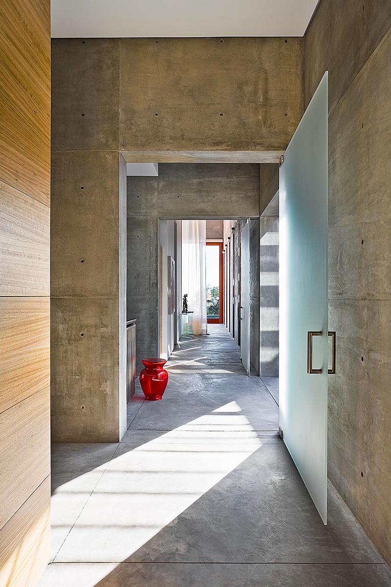 An entry way that is smart combination of natural wood, glass and concrete