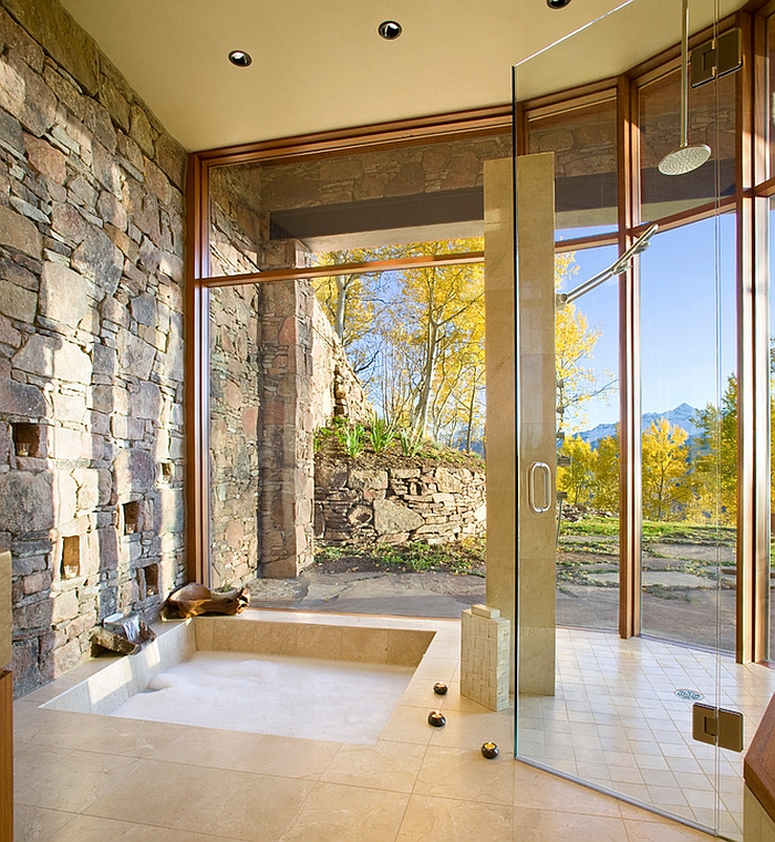 Bathroom with a natural stone wall, marble floor and sunken tub