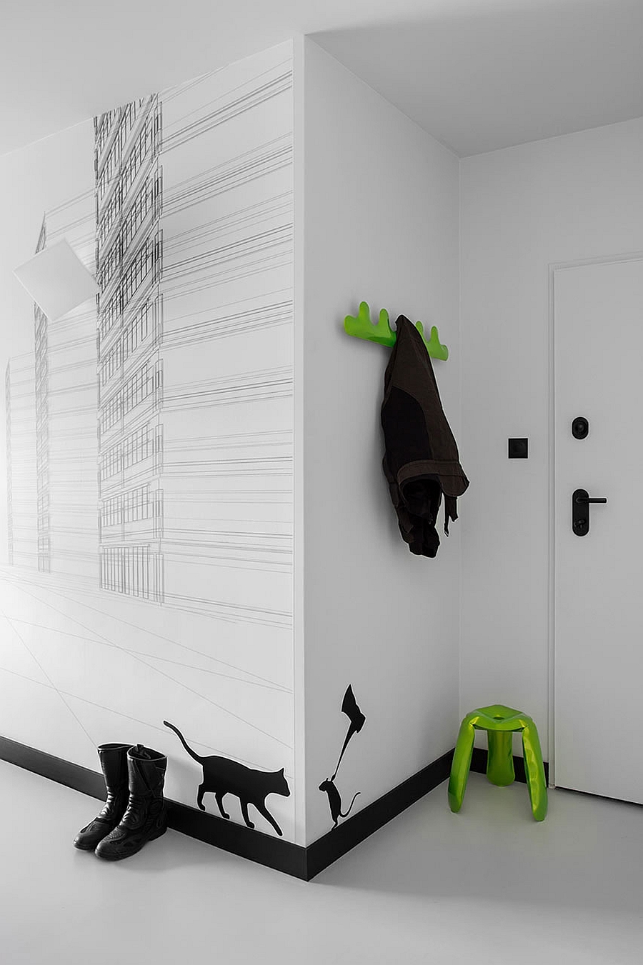 Black and white wall decals and bright pops of green welcome you at the entrance of the apartment