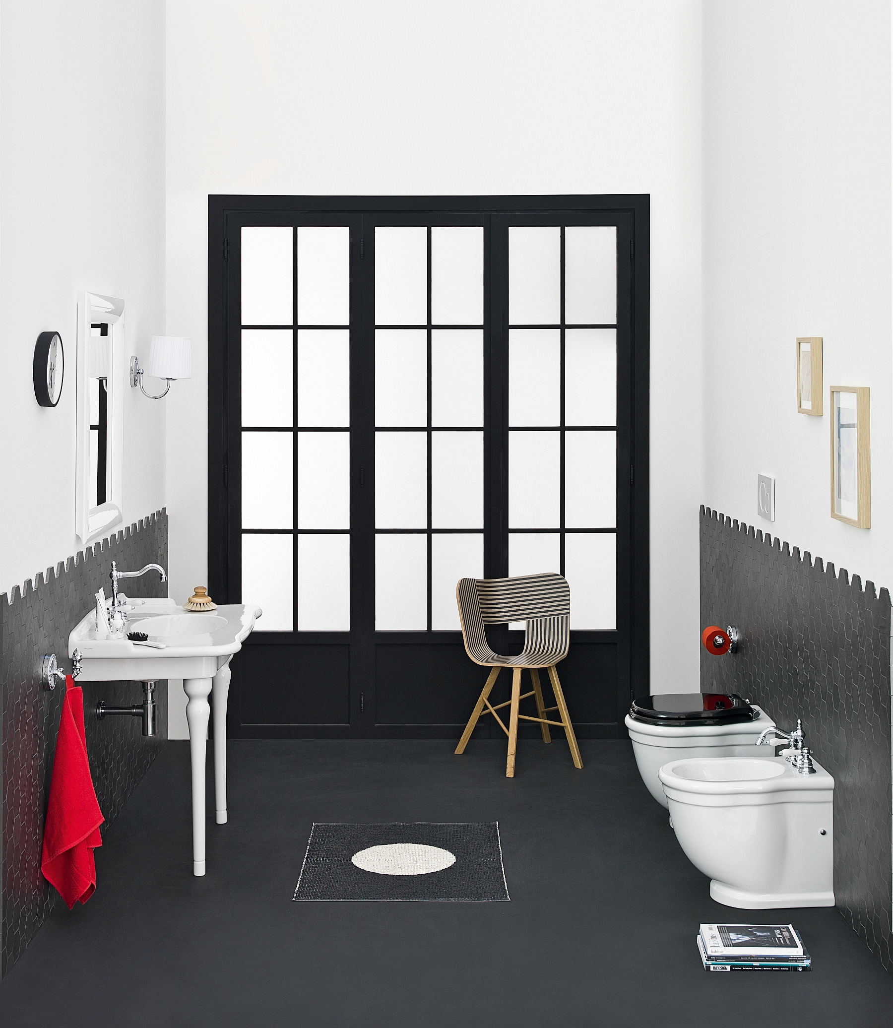 Black framed door adds drama to the bathroom while pops of red enliven it with ease