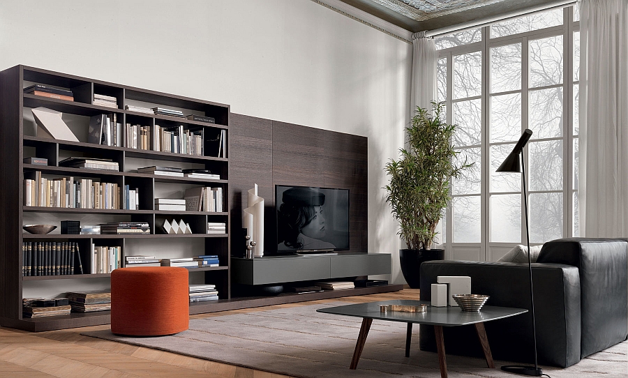 Bright orange ottoman adds a splash of color to the room with stunning wall unit system