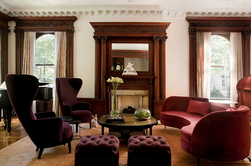 Curved sofa coupled with Tom Dixon wingback chairs in eggplant and plush ottomans