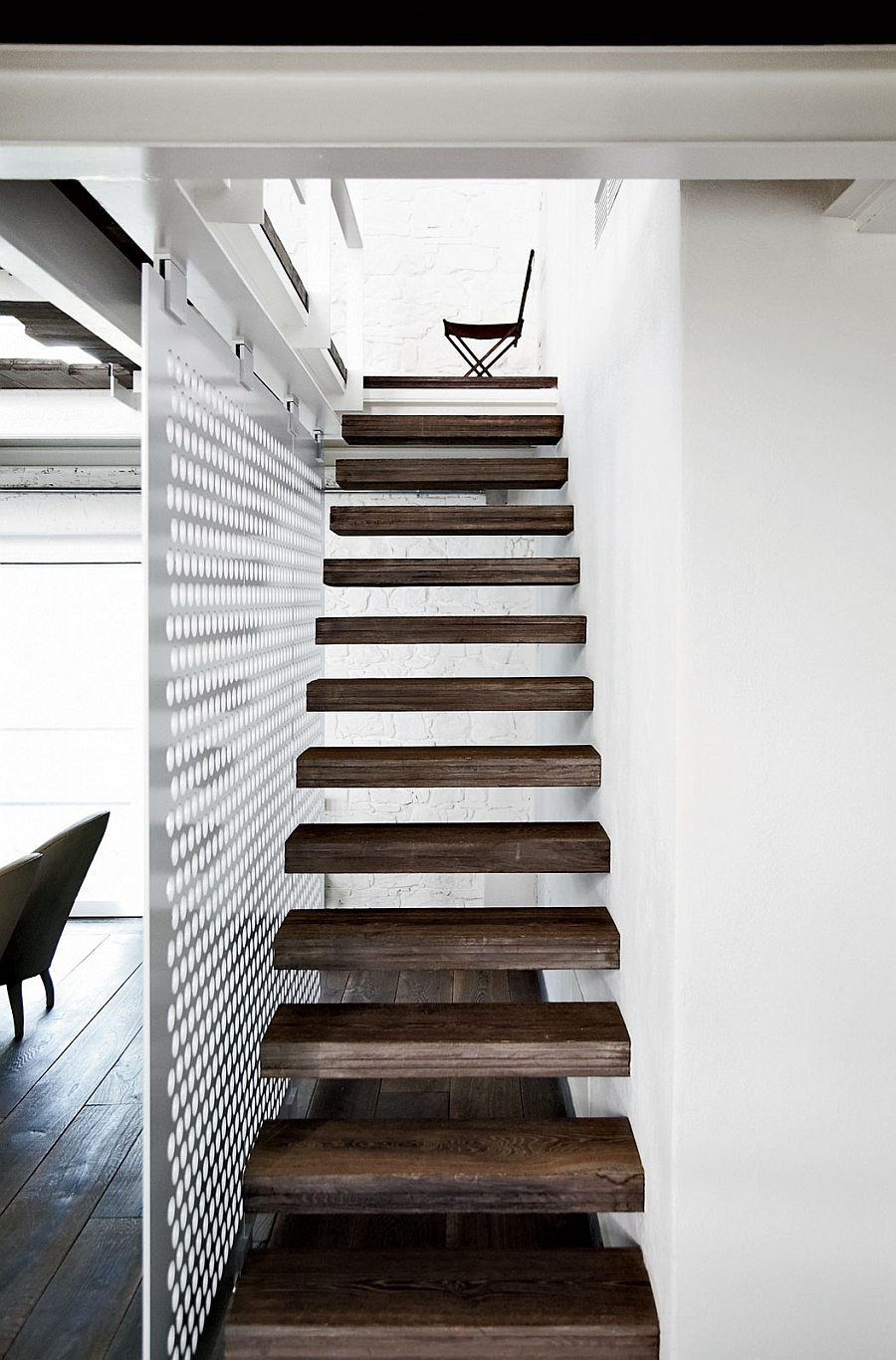 Floating wooden staircase standsout visually thanks to the white backdrop