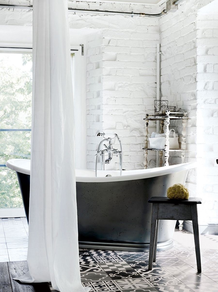 Freestanding bathtub in black set against a white brick wall in the relaxing bath