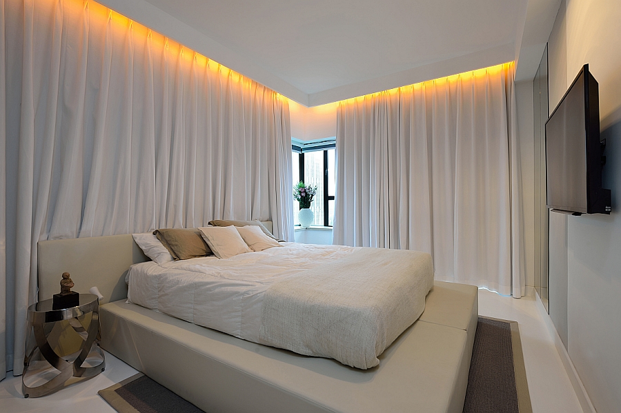 Long, white drapes turn the bedroom into a serene sanctuary