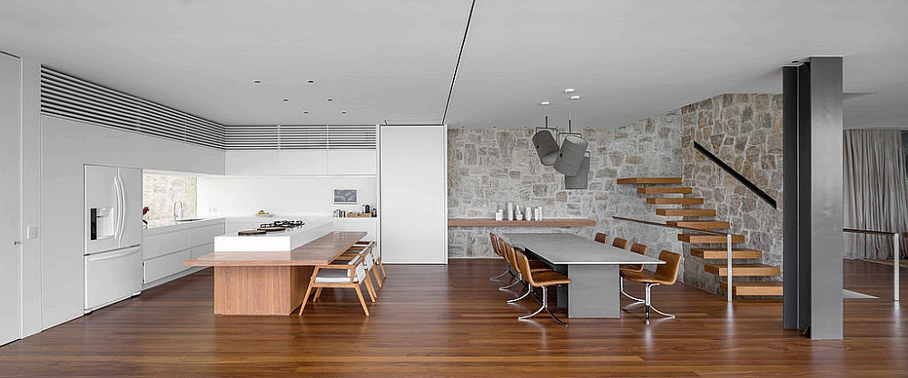 Modern dining room and kitchen with a stone backdrop