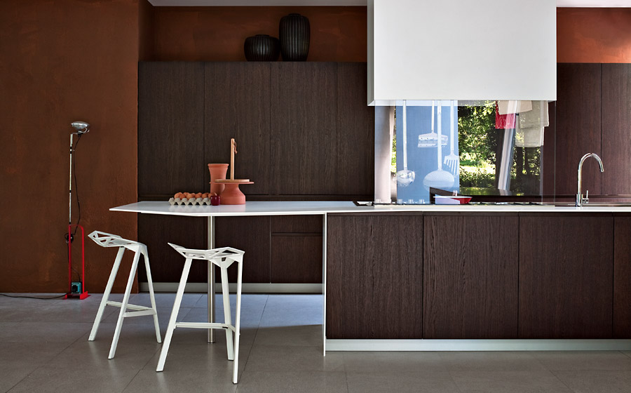 Sculptural bar stools add lovely visual contrast to the kitchen in dark wood tones