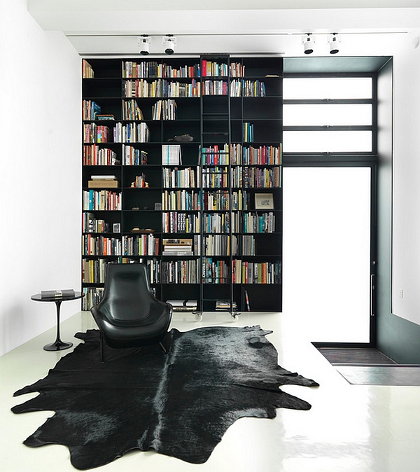 Uber-stylish blacka nd white living room with a giant bookshelf that defines the space