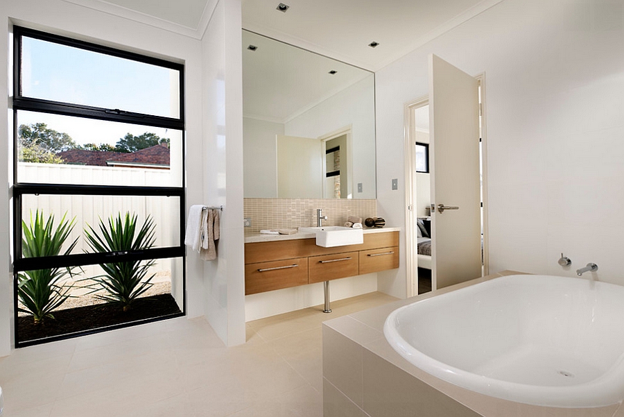 Wooden vanity and natural greenery give the bath a relaxing, trendy look