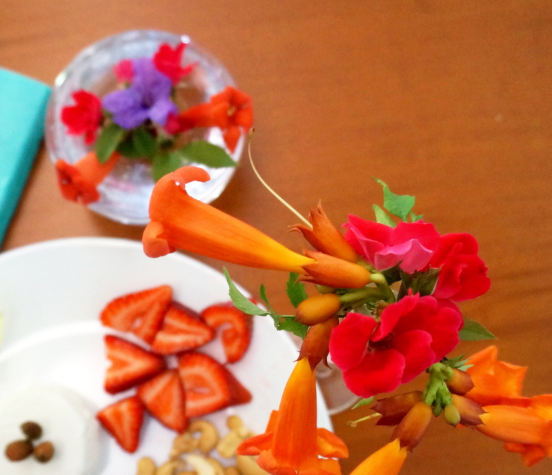 Blossoms in glass vases surround a food plate