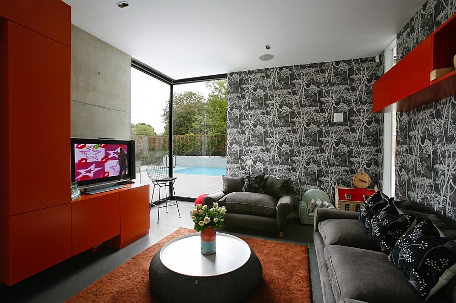 Bold red shelves and wallpaper add style to the sitting room