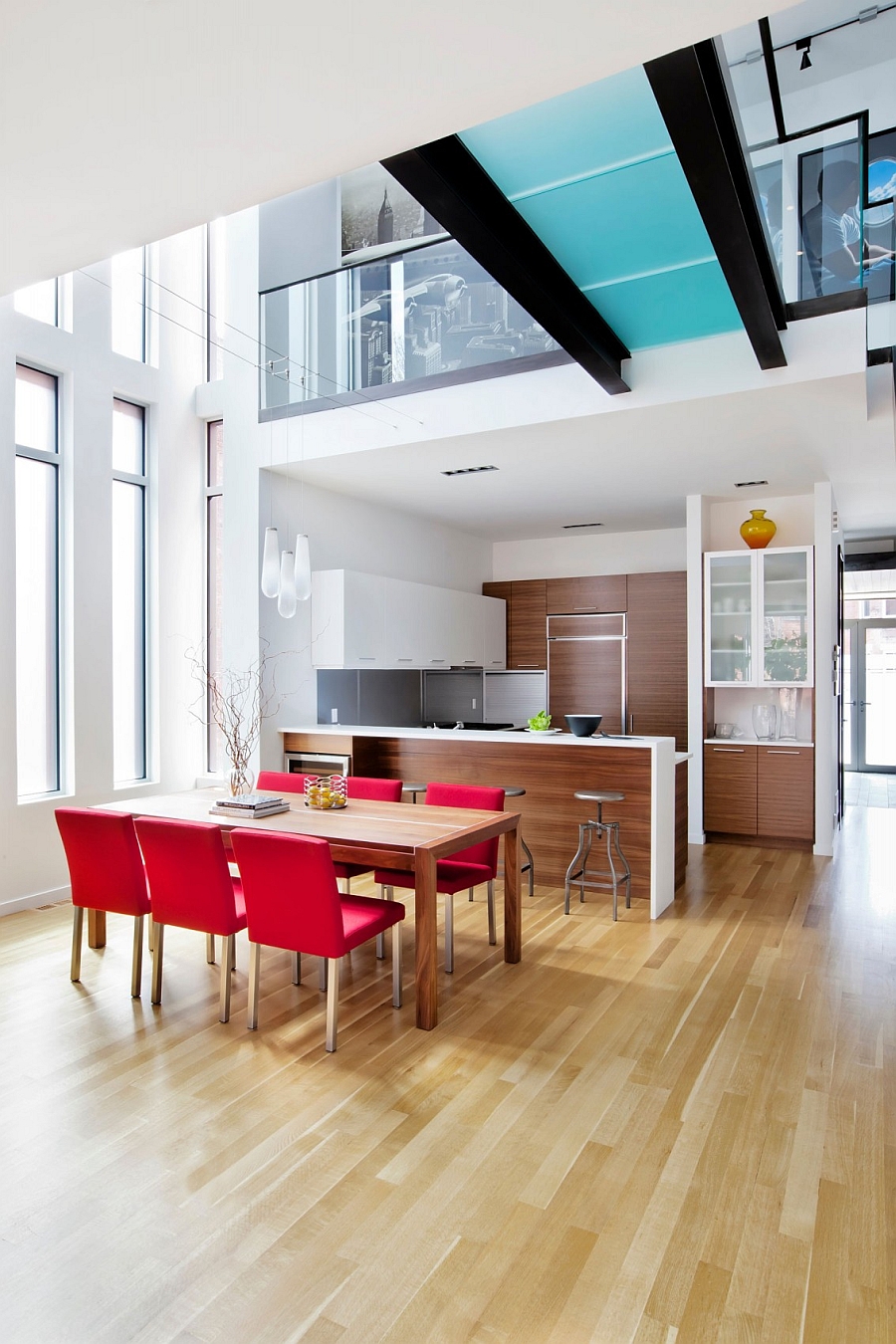 Dining table chairs add bright pops of red to the trendy interior