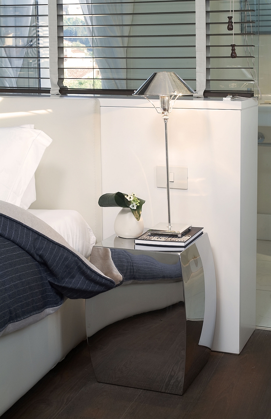 Flashy nightstand adds a cool reflective surface to the small bedroom