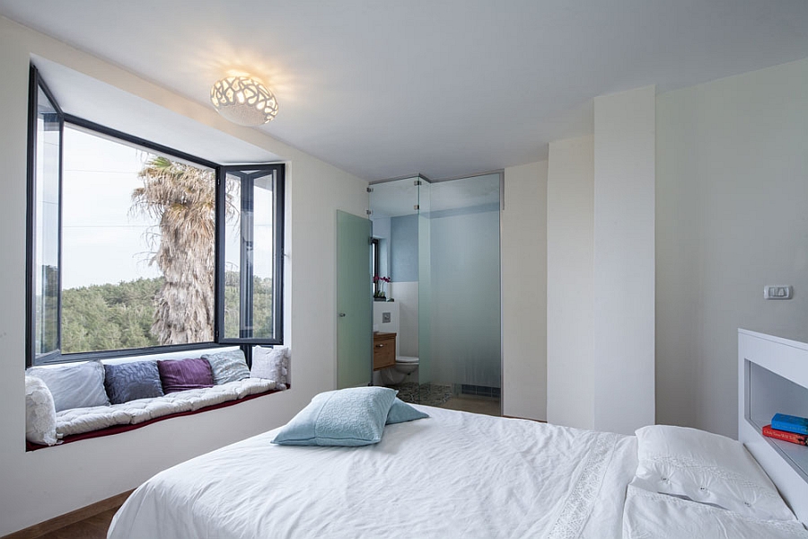 Master bedroom with an en shiute bathroom and window niche that offers scenic views