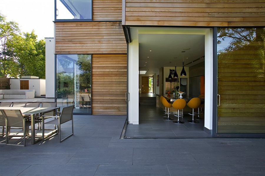 Sliding glass doors in the corner connect the interior with the outdoors