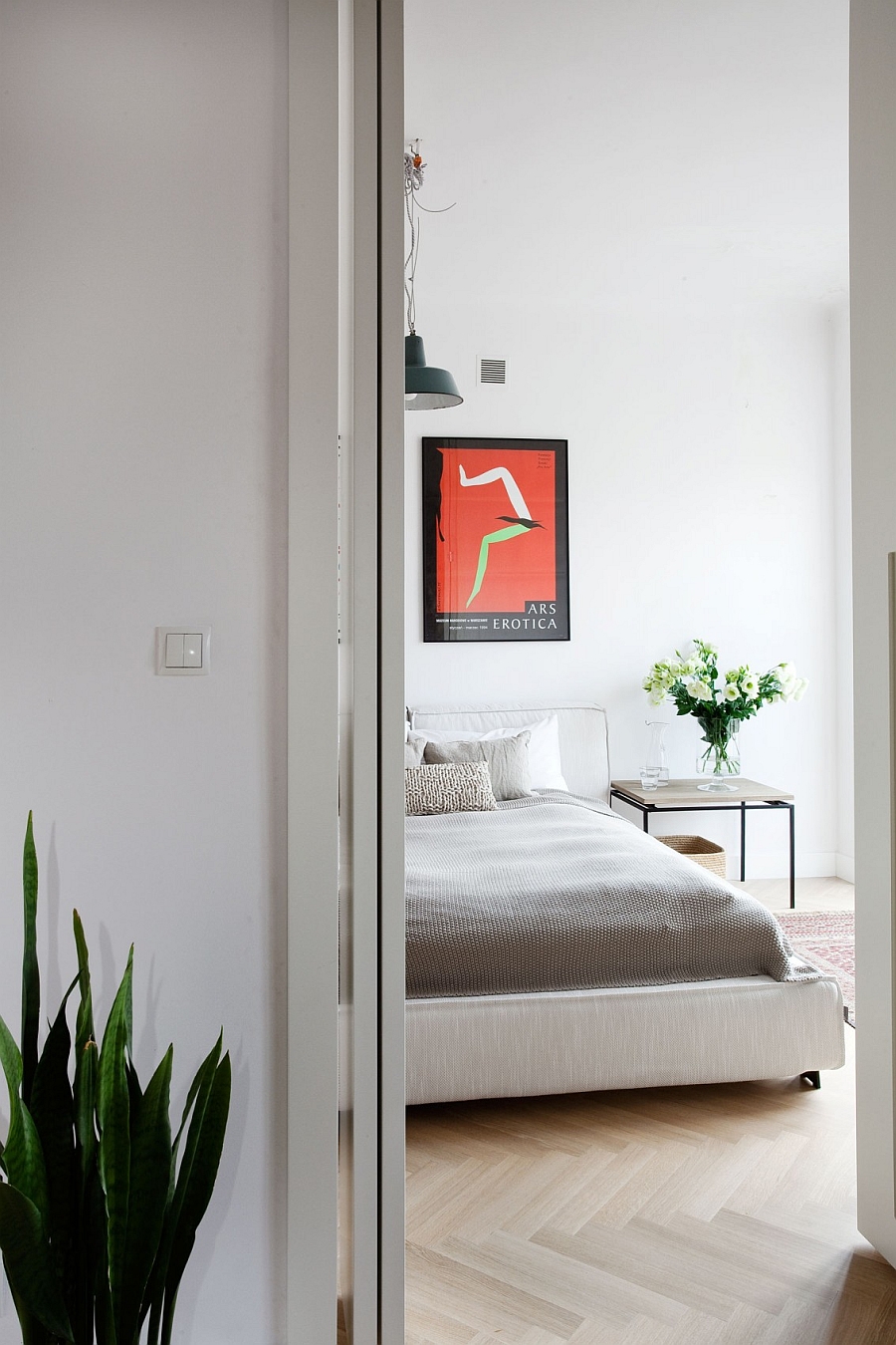 Smart side table and flowers add natural zest to the serene bedroom