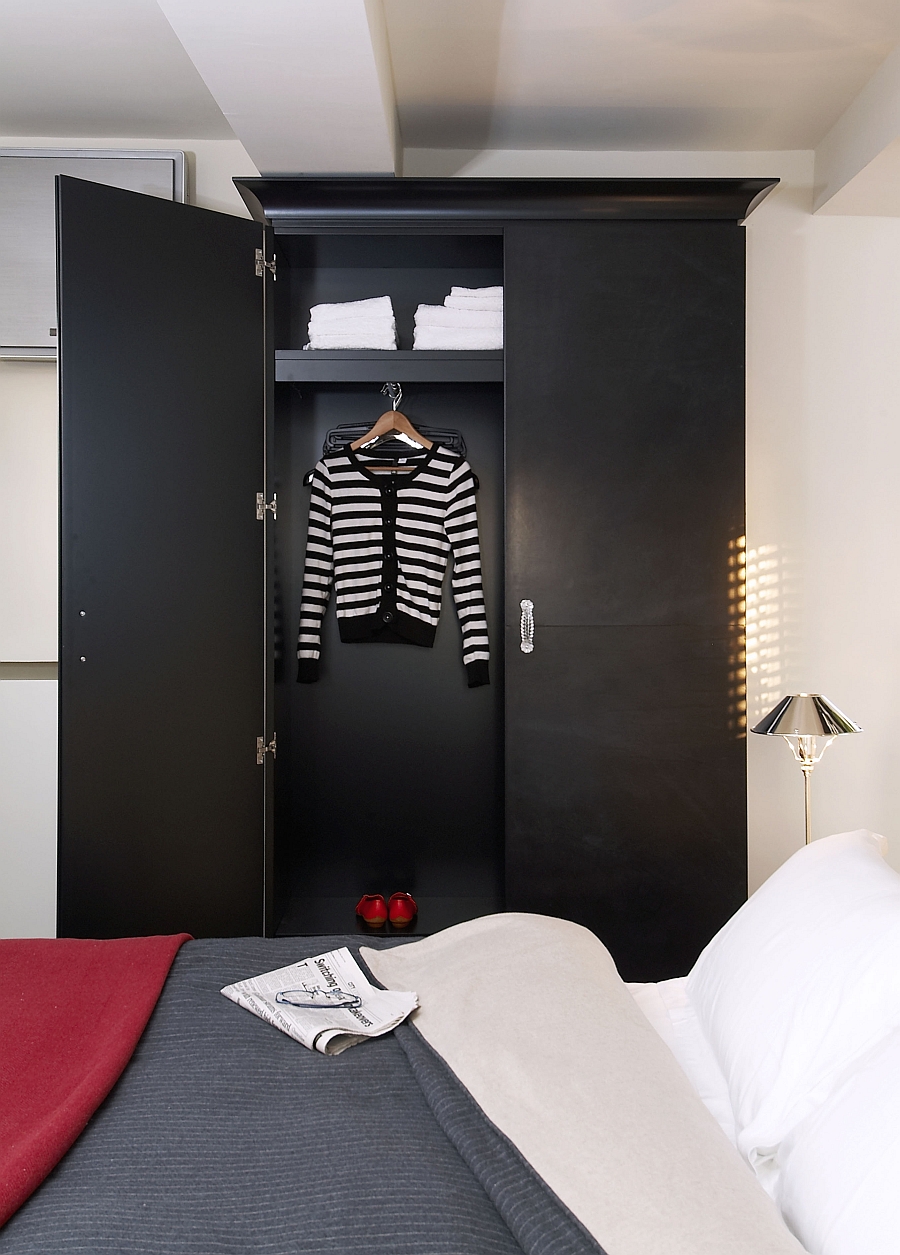 The wardrobe in black brings visual contrast to the room