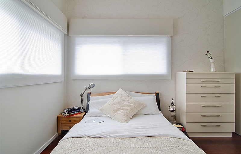 Wallpaper adds subtle elegance to the soothing master bedroom in the small apartment