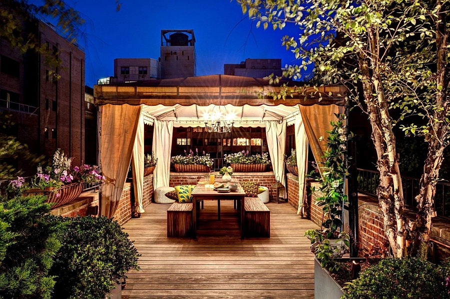 An outdoor dining space nestled among natural greenery of the rooftop garden