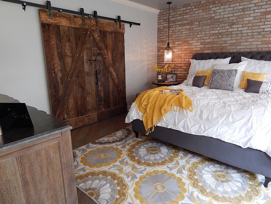 Basement bedroom with brick walls and large barn-like door [By VIP Interior Design]