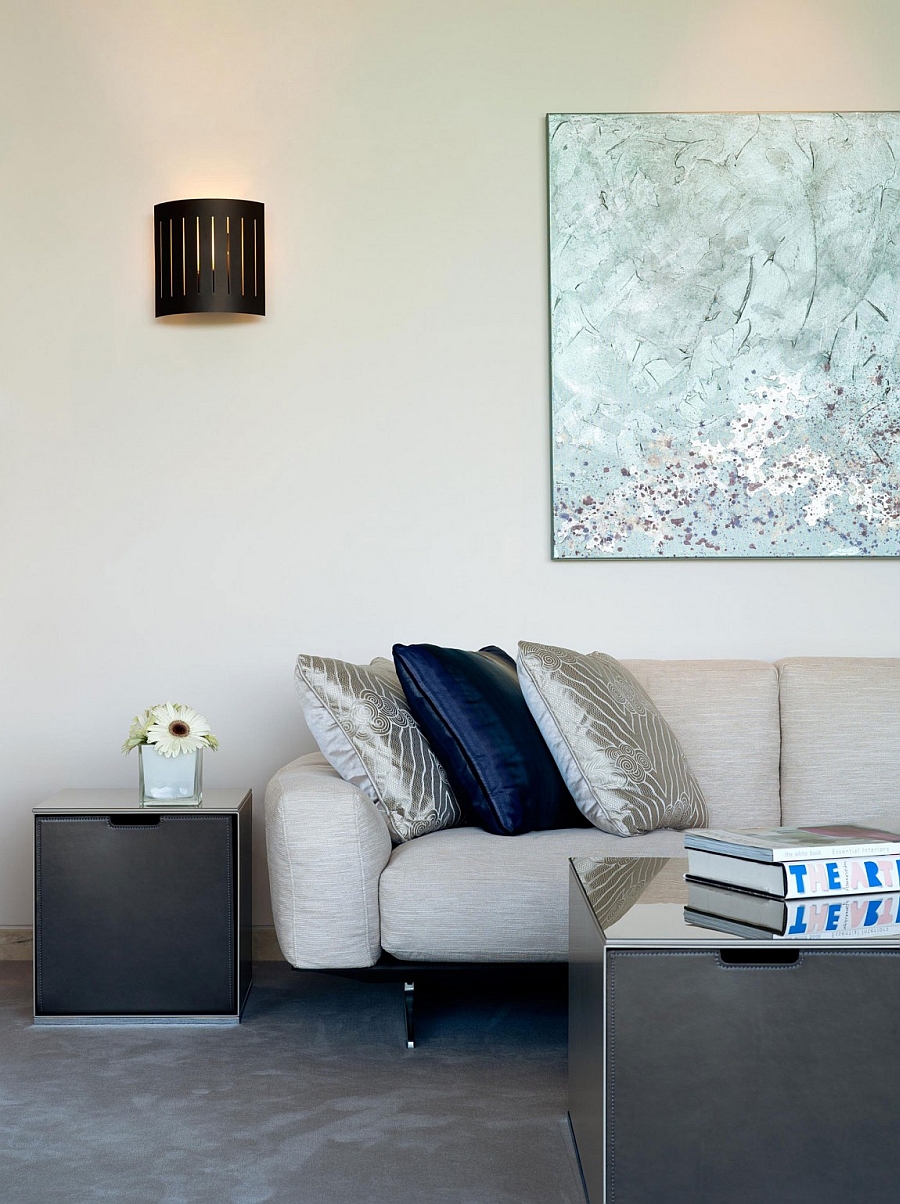 Navy blue and silver accent pillows on light grey couch