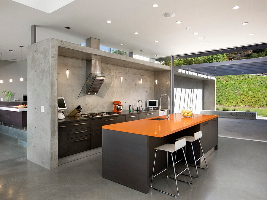 Industrial kitchen with an orange quartz countertop and dark island [Design: Abramson Teiger Architects]