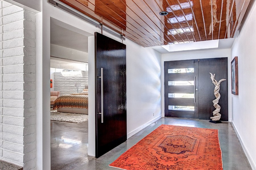 Large barn door used to separate the master suite from the gorgeous entry with pops of red