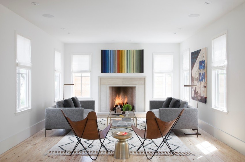 Modern art and a textured rug in a living room with a fireplace