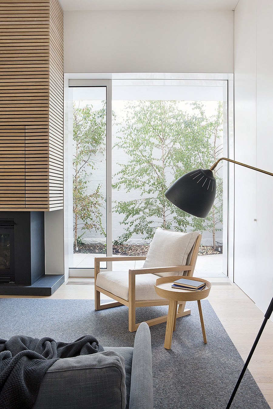 Reading spot next to the fireplace with pale timber chair