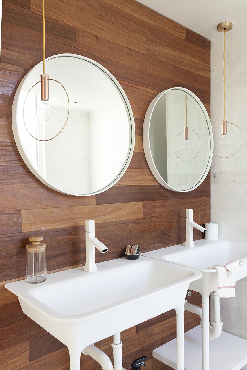 Round mirrors and pendant lighting in a modern bathroom