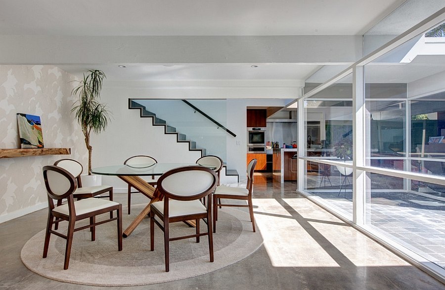 Snazzy dining room has an open and airy appeal thanks to the use of glass