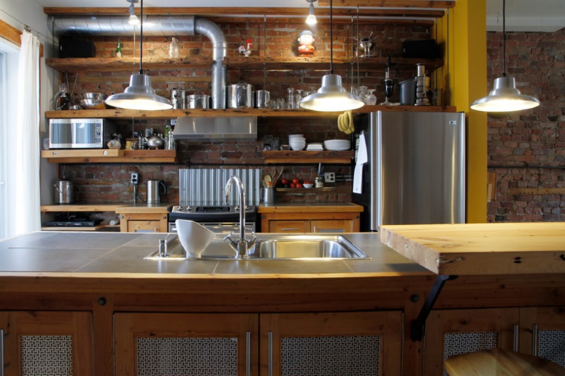 Stainless steel pots on open shelving in an industrial kitchen
