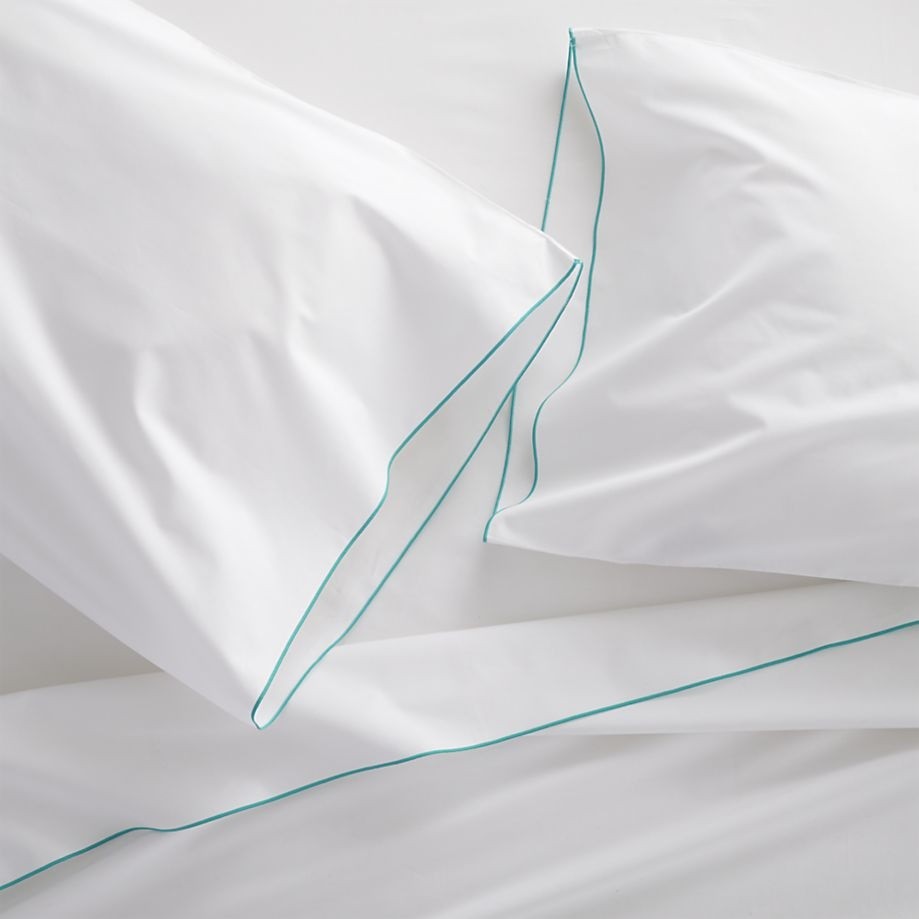White sheets and shams with an aqua trim