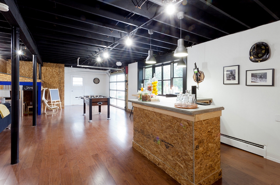 Basement bar with a foosball table and relaxed hangout next to it