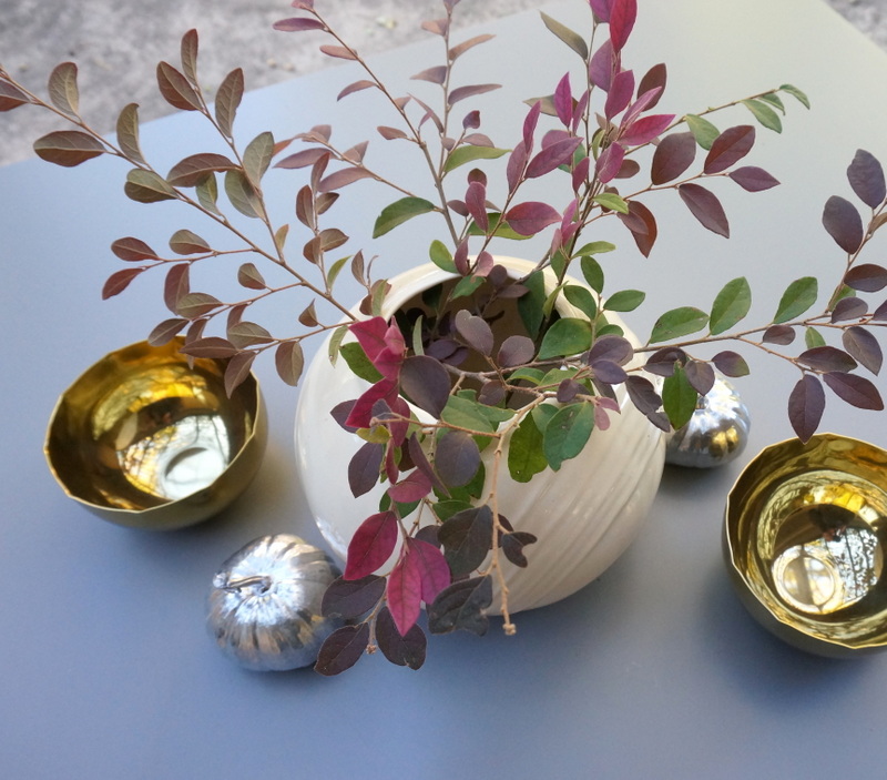Brass bowls, painted pumpkins and a vase of branches