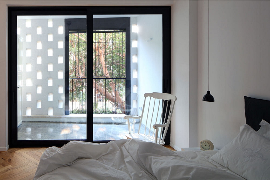 Brick wall and glass window usher in ample ventilation into the bedroom