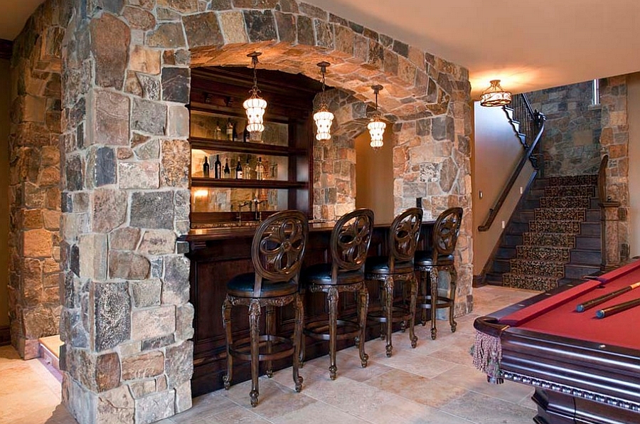 Classic basement bar design with a pool table next to it [Design: Hendel Homes]